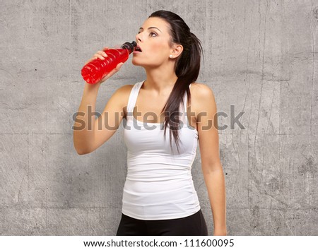 Young girl having isotonic drink, indoor