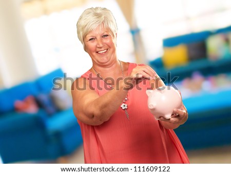 Woman Putting Coin In Piggy Bank, Indoor
