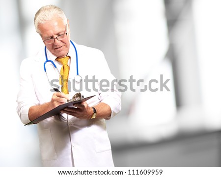 Senior Male Doctor Writing On Clipboard, Indoor