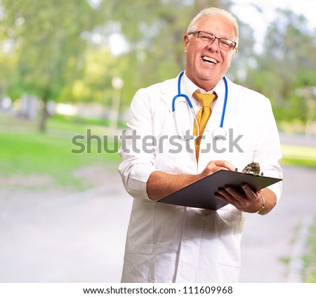Happy Male Doctor Writing On Clipboard, Outdoor