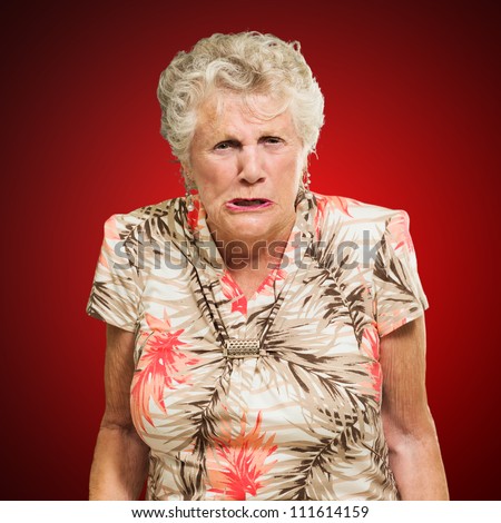 Portrait Of Angry Senior Woman Isolated Over Red Background