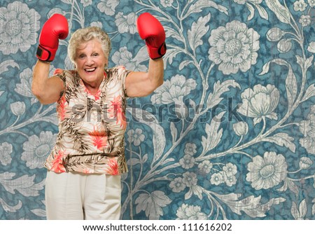 Portrait Of Senior Woman Wearing Boxing Glove With Floral Pattern Background