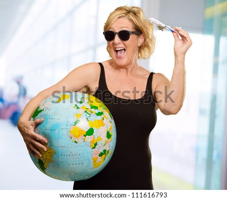 Woman Holding A Miniature Airplane And Globe, Indoors