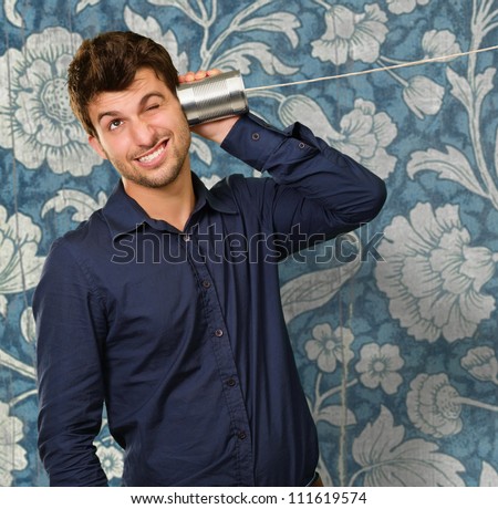 Man Listening From Tin Can Telephone Near Flora Wallpaper