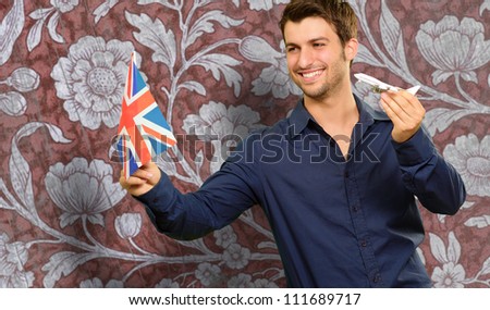 Man Holding A Miniature Airplane And British Flag On Flora Background
