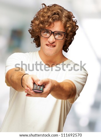 Portrait Of Young Man With Glasses Changing Channel With Tv Control, Indoor