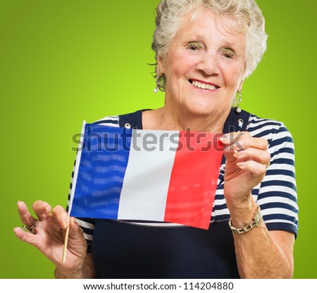 Happy Senior Woman Holding France Flag Isolated On Green Background