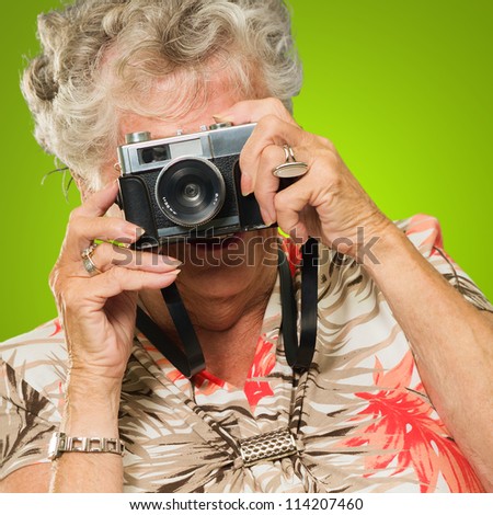 Senior Woman With Old Camera Isolated On Green Background