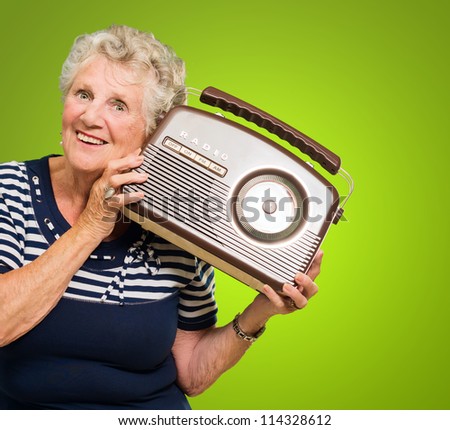 Senior Woman Listening Music On Radio Isolated On Green Background