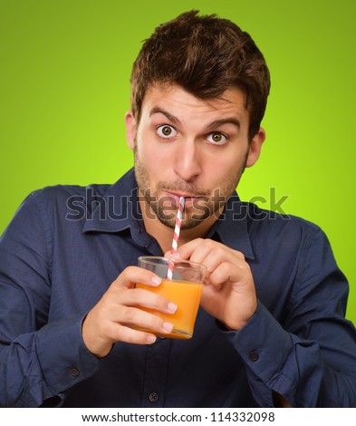Young Man Drinking Juice On Green Background