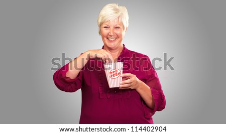 Old Woman Eat Popcorn On Gray Background