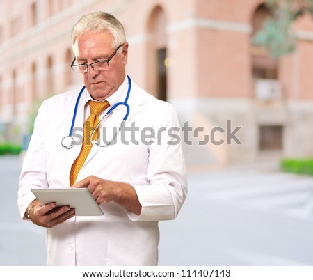 Portrait Of A Male Doctor Holding A Tab, Outdoor