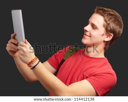 casual man holding digital tablet isolated on black background