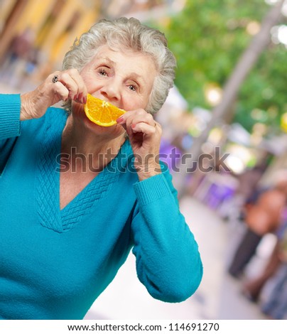 Mature Woman With A Slice Of Fruit, Outdoor