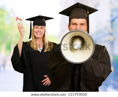 Male And Female Graduate Students With Diploma And Yelling On Megaphone