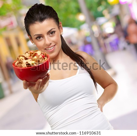 Young woman holding a cereal bowl, outdoor