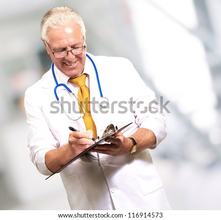 Happy Male Doctor Writing On Clipboard, Indoor