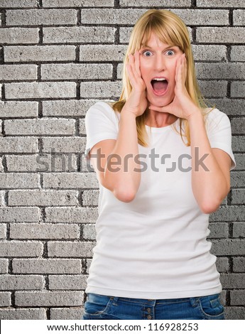 Portrait Of Shocked Woman against a grey brick wall background