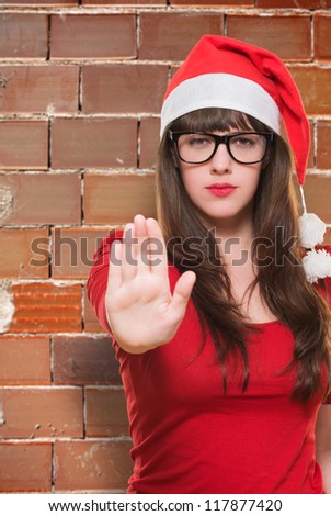christmas woman doing a stop gesture against a brick wall