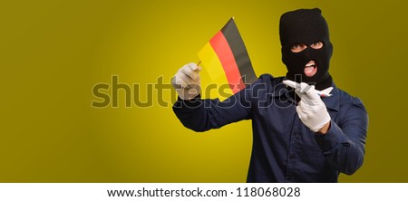 Man wearing a robber mask and holding airplane miniature and flag on yellow background