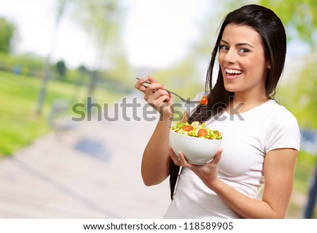 Young Girl Eating Salad From Bowl, Outdoor