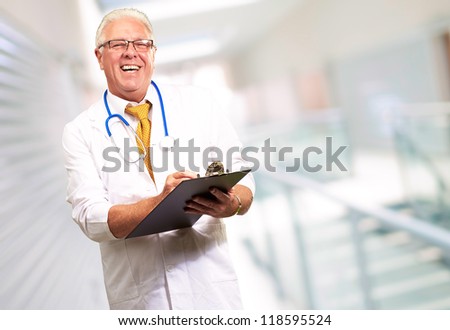 Happy Male Doctor Writing On Clipboard, Indoor
