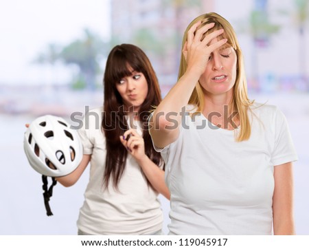 Woman Holding Safety Helmet In Front Of Unhappy Woman, Outdoors