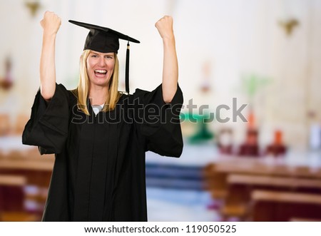 Happy Graduate Woman In Gown in an assembly hall room