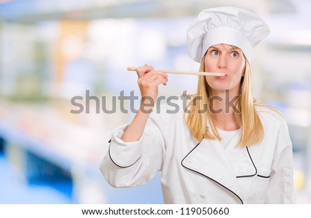 Female Chef Tasting Food against an abstract background