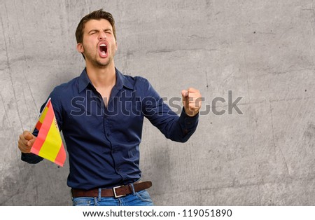 Man cheering and holding flag, indoor