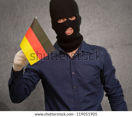Man wearing robber mask and holding flag, indoor