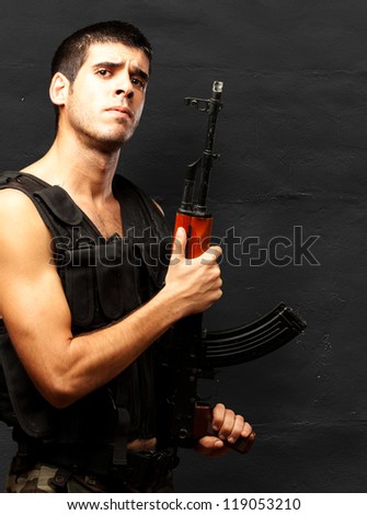 Portrait Of Soldier Holding Gun against a grunge background