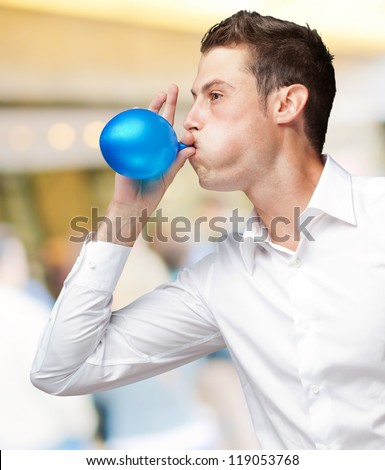 Portrait Of Young Man Blowing Balloon, Outdoor