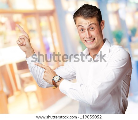 Portrait Of A  Excited Young Man Pointing Up, Indoor