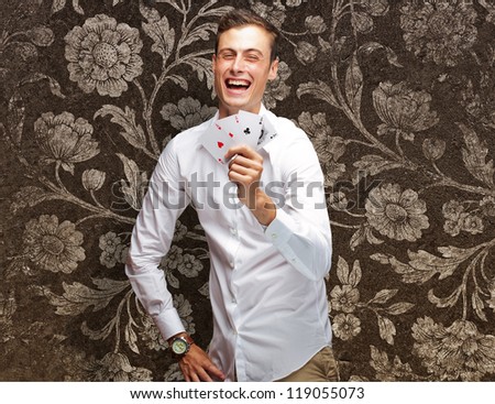 Portrait Of Young Man Showing Poker Cards On Flora Wallpaper