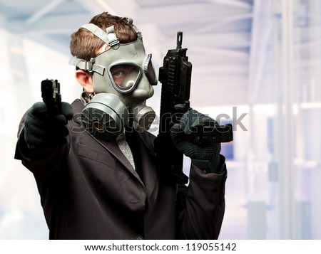 Businessman Holding Gun With Gas Mask against an abstract background
