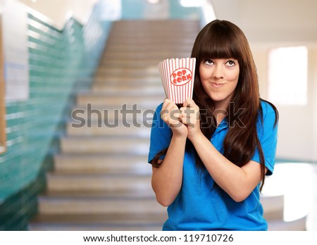 girl holding empty popcorn packet, indoor