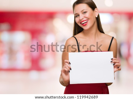 Happy Young Woman Holding Blank Placard against an abstract background