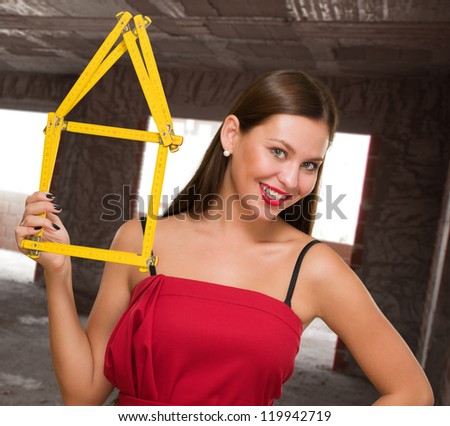 Happy Young Woman Holding House Frame, indoor