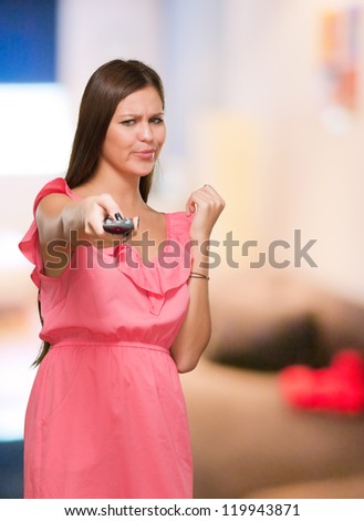 Young Woman Changing Channel at her home
