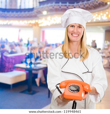 Female Chef Holding Telephone in a restaurant