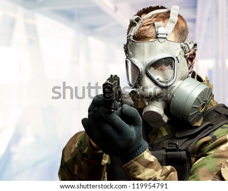Portrait Of A Soldier With Gas Mask Aiming With Gun, indoor
