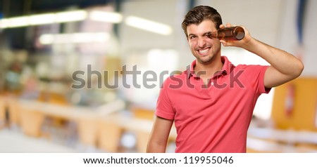 man looking inside an empty bottle, indoor
