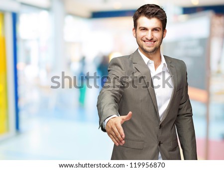 Portrait Of  Young Businessman In A Suit Holds Out His Hand For A Handshake, Indoor