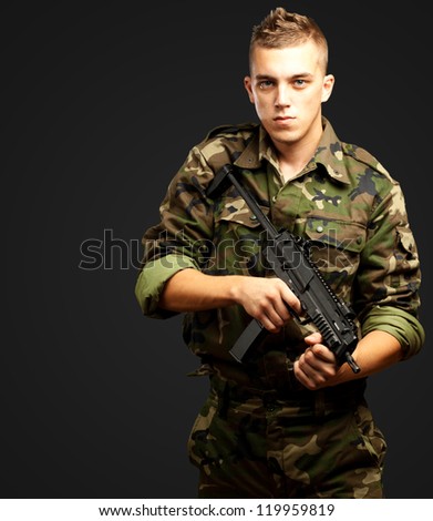stock-photo-handsome-soldier-holding-gun-against-a-black-background-119959819.jpg