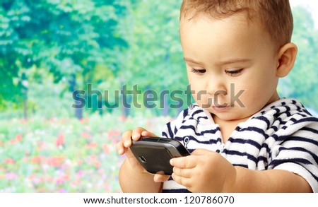 Portrait Of Baby Boy Using Cell Phone, outdoor