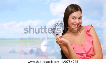 Happy Young Woman Holding Euro Currency at an airport
