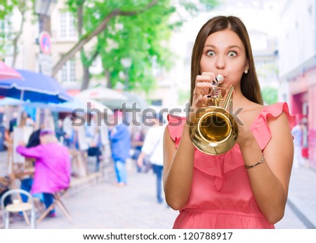 Young Woman Blowing Trumpet at a market