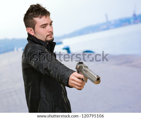Portrait Of A Man Holding Gun at a port