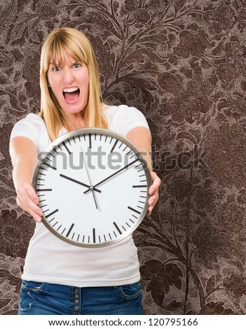 Portrait Of A Angry Woman Holding Clock against a vintage background